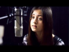 a woman with long hair sitting in front of a microphone and looking off into the distance