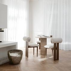 a table and chairs in a room with white curtains