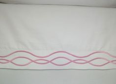 a white bed with pink lines on it