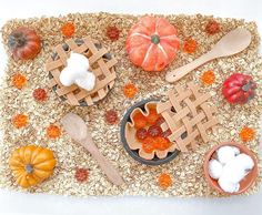 a table topped with wooden utensils and pumpkins