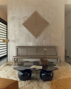 a modern looking living room with two black vases and a bench in the middle