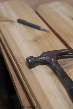 an old pair of hammers sitting on top of a wooden table next to a pair of pliers