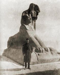 a man standing next to a giant statue