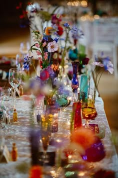 the table is covered with colorful glass vases