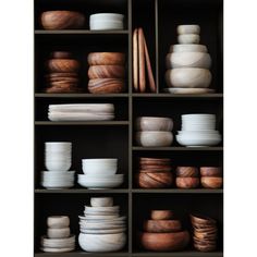 the shelves are filled with different types of wooden bowls and plates in varying shapes and sizes