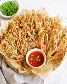 a basket filled with fried food and dipping sauce