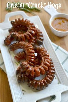 some very tasty looking food on a white plate with dipping sauce in the background