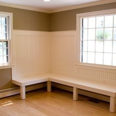 empty room with two windows and bench in the corner on hard wood flooring area