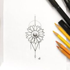 a drawing of a sunflower on paper next to colored pencils