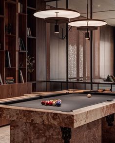 a pool table in the middle of a room with several billiards on it