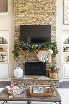 a living room decorated for christmas with stockings on the mantle