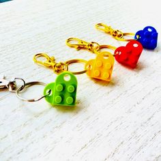 four different colored lego key chains on a table