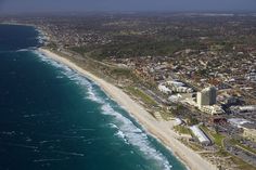 an aerial view of a city next to the ocean with buildings and beachfronts