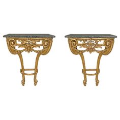 a pair of gold and black marble topped tables