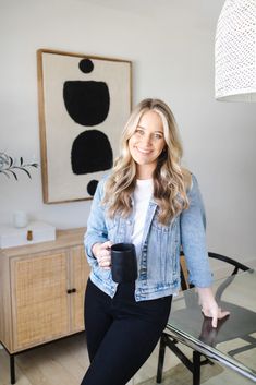 a woman standing next to a glass table