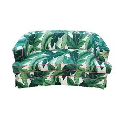 a green and white couch with palm leaves on it