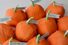 there are many orange pumpkins with name tags attached to the top and bottom of them