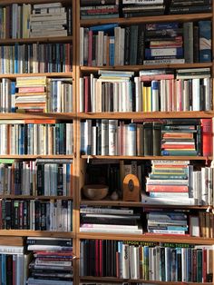 a bookshelf filled with lots of books next to a wall full of books