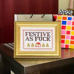 a cross - stitch picture frame with the words festive as fock on it