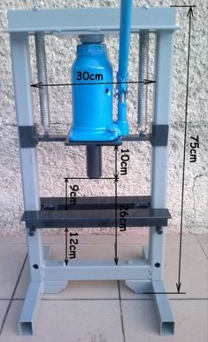 a blue water pump sitting on top of a metal stand next to a brick wall