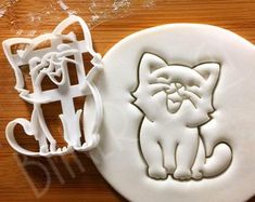 two cookie cutters sitting next to each other on top of a wooden table with icing