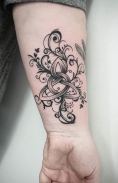 a woman's arm with a tattoo on it and an intricate design in the middle