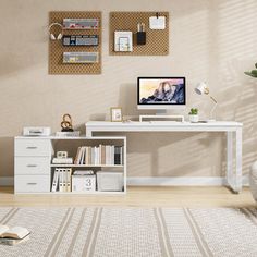 a white desk with a computer on top of it in front of a beige wall