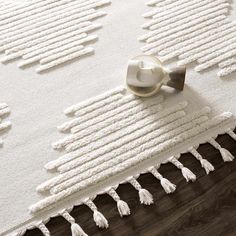 a white rug with tassels on top of it