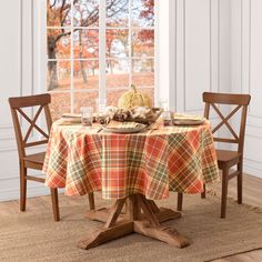 the table is set for two with an orange plaid tablecloth and matching wooden chairs