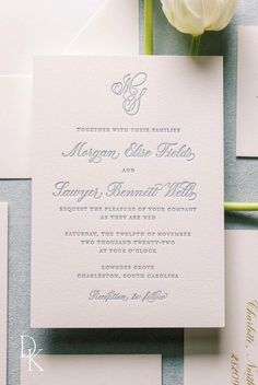 the wedding stationery is laid out on top of each other, with a single flower in the center