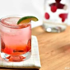 two glasses filled with drinks sitting on top of a wooden table