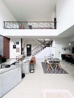 a living room filled with furniture and a spiral stair case next to a table on top of a rug