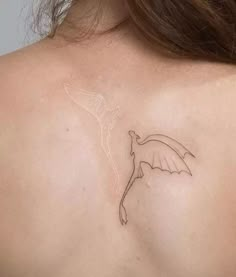 the back of a woman's shoulder with a small tattoo on her left side