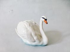 a white swan figurine sitting on top of a table