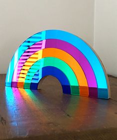 a rainbow shaped object sitting on top of a wooden table