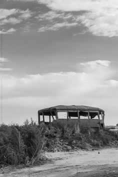 an abandoned bus sitting on top of a grass covered hill