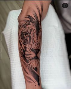 a man's arm with a black and grey tattoo of a tiger on it