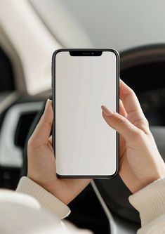 a woman holding up a cell phone in her hand with a blank screen on it