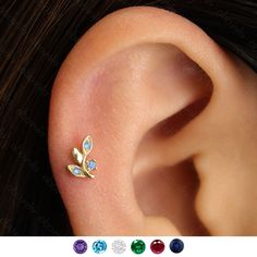 an ear piercing with three different colored stones