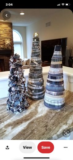 three small christmas trees sitting on top of a counter next to a fireplace in a living room