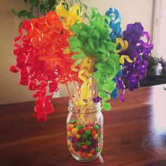 a glass jar filled with candy sitting on top of a wooden table