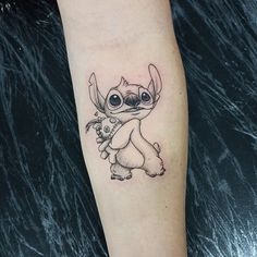 a small tattoo on the leg of a person's arm with an image of a baby groote holding a flower