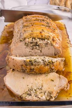 sliced pork roast with herbs on it in a pan