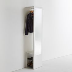 a white closet with a coat hanging on it