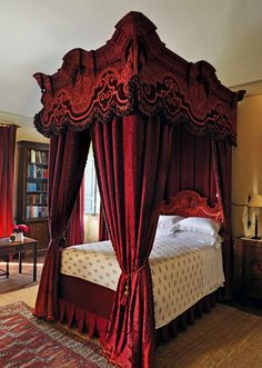 the canopy bed is made up with red curtains