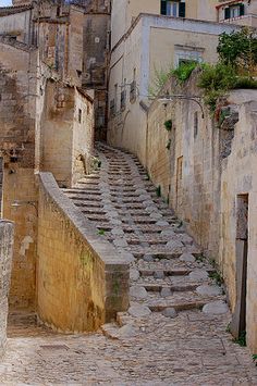 an old stone street with steps leading up to buildings