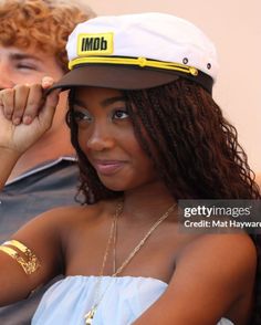 a woman wearing a hat sitting next to a man