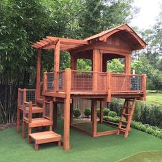 a wooden play set in the middle of a grassy area with stairs leading up to it