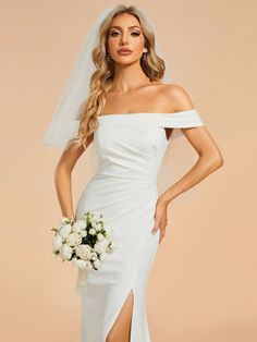 a woman wearing a white wedding gown with a slit down the side and flowers in her hair