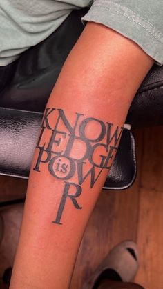 a person with a tattoo on their leg that says know and power is in the air